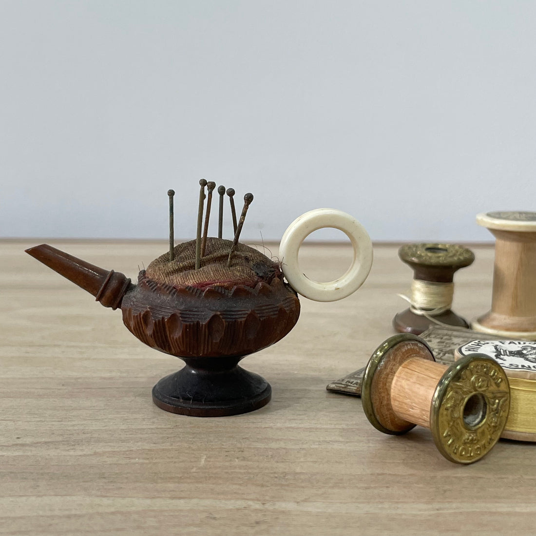 Antique wooden pin cushion shaped as teapot with bone handle and seven Tudor pins